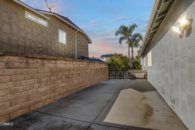 property exterior at dusk with a patio area