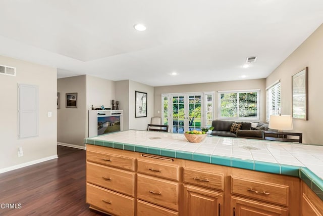 kitchen with tile counters, dark hardwood / wood-style floors, and french doors