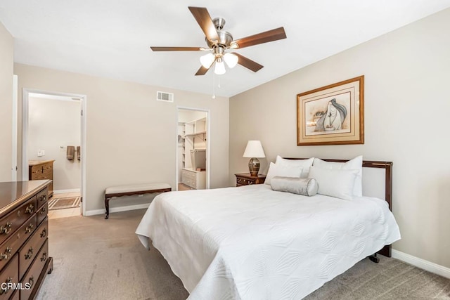 carpeted bedroom featuring ceiling fan and ensuite bath