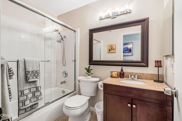 full bathroom featuring enclosed tub / shower combo, vanity, and toilet