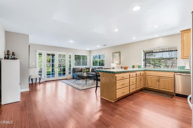 kitchen featuring french doors, stainless steel dishwasher, kitchen peninsula, and light brown cabinets