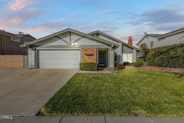 view of front of home with a garage and a lawn