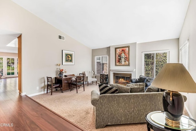 living room with wood-type flooring and high vaulted ceiling