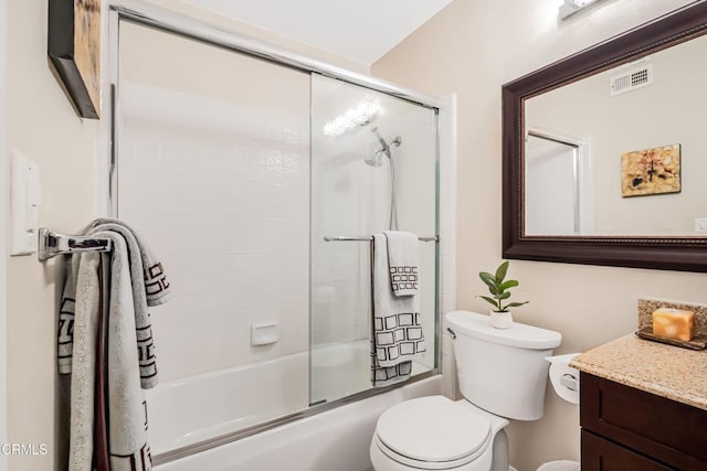 full bathroom featuring vanity, shower / bath combination with glass door, and toilet