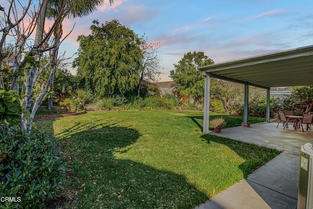 yard at dusk featuring a patio area