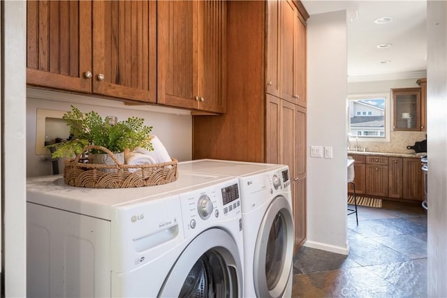 laundry room with cabinets, sink, ornamental molding, and independent washer and dryer