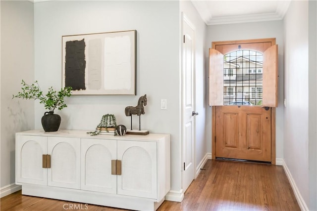 doorway with ornamental molding and light hardwood / wood-style floors