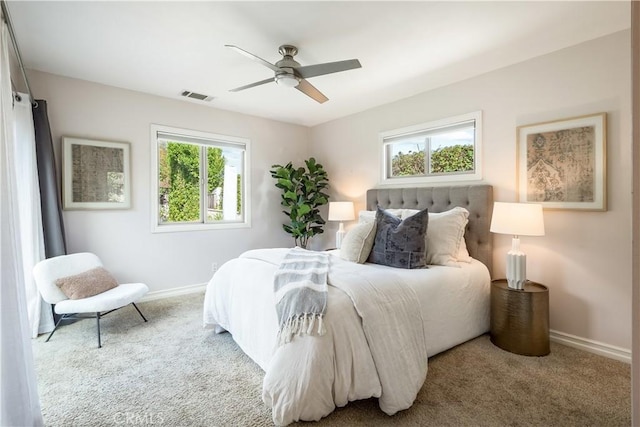 carpeted bedroom with ceiling fan and multiple windows