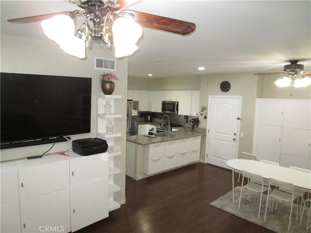 kitchen with sink, white cabinetry, dark hardwood / wood-style floors, ceiling fan, and stainless steel appliances