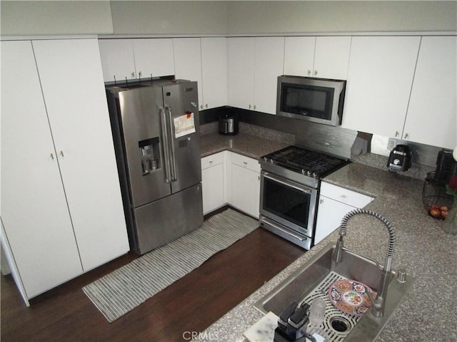 kitchen featuring stainless steel appliances, dark hardwood / wood-style floors, sink, and white cabinets