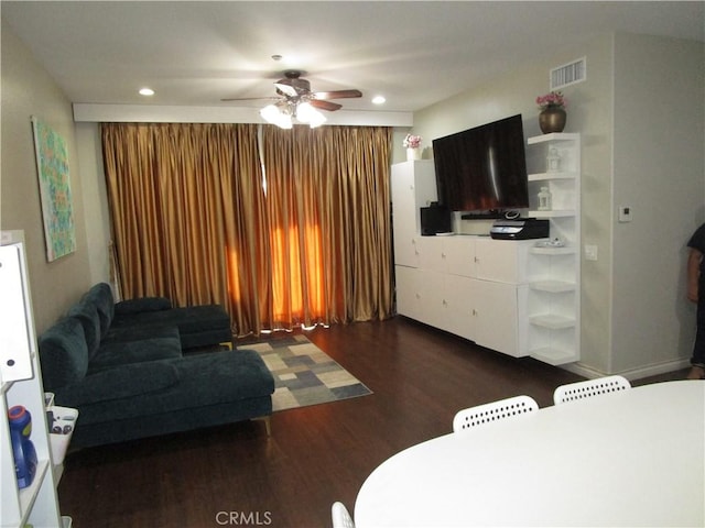 living room featuring ceiling fan and dark hardwood / wood-style flooring