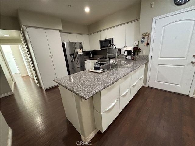 kitchen featuring sink, appliances with stainless steel finishes, dark hardwood / wood-style floors, kitchen peninsula, and white cabinets