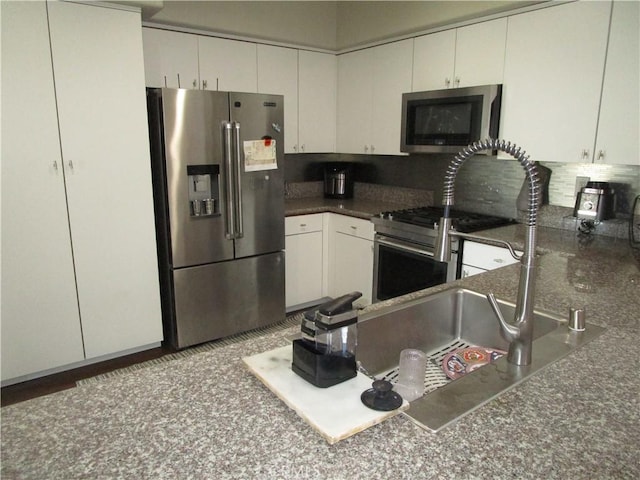 kitchen featuring white cabinetry, backsplash, and appliances with stainless steel finishes