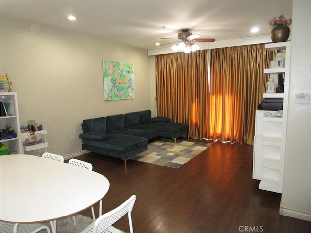 living room featuring ceiling fan and dark hardwood / wood-style floors