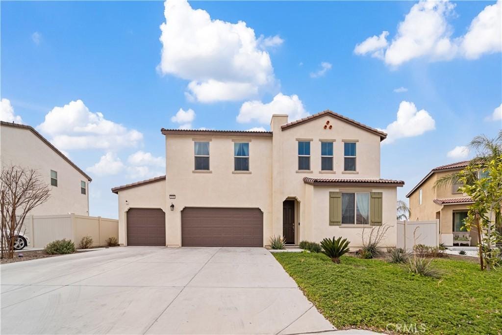 mediterranean / spanish house with a garage and a front yard