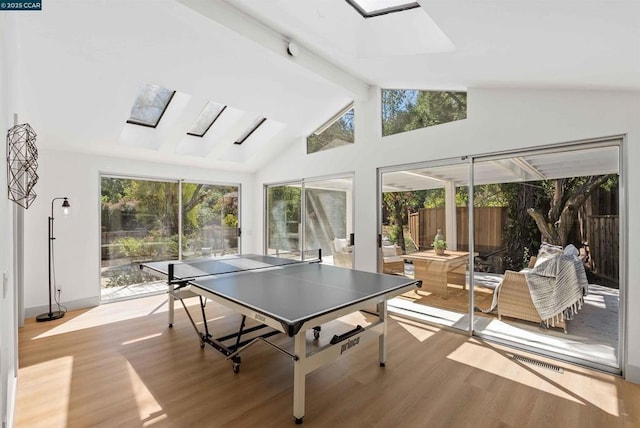 recreation room featuring a skylight, light hardwood / wood-style floors, and a healthy amount of sunlight