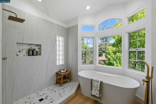 bathroom with plus walk in shower, vaulted ceiling, hardwood / wood-style floors, and a wealth of natural light