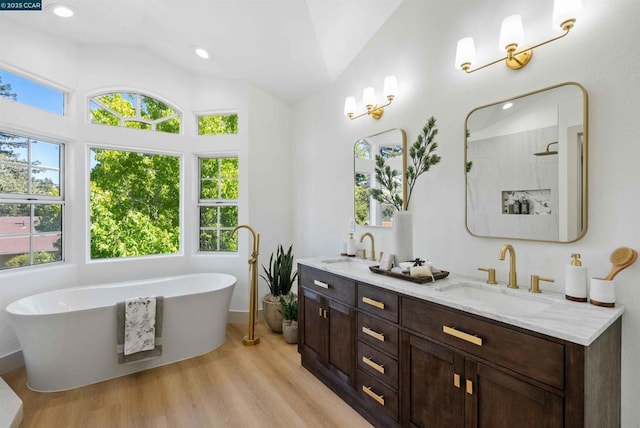 bathroom featuring vanity, hardwood / wood-style floors, lofted ceiling, and shower with separate bathtub