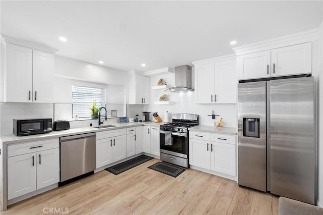 kitchen with white cabinets, sink, wall chimney exhaust hood, and appliances with stainless steel finishes