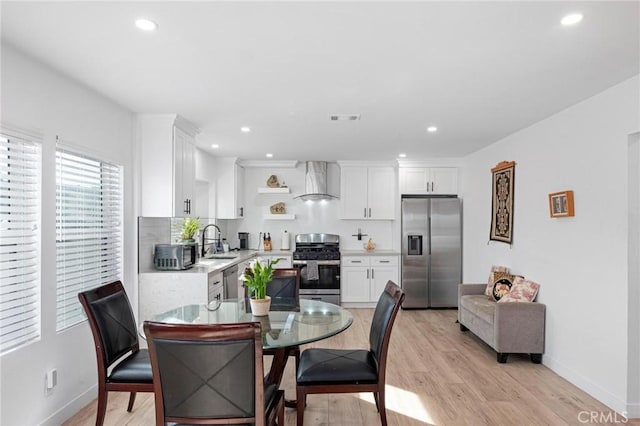 dining space with sink and light hardwood / wood-style floors