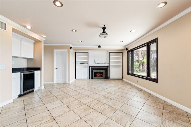 unfurnished living room featuring wine cooler, light tile patterned floors, and crown molding