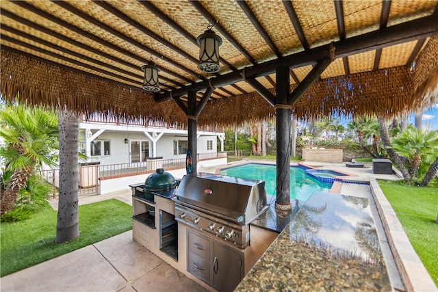 view of patio featuring a swimming pool with hot tub, grilling area, and exterior kitchen