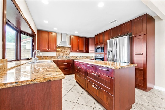 kitchen featuring sink, light stone countertops, wall chimney exhaust hood, and stainless steel refrigerator with ice dispenser