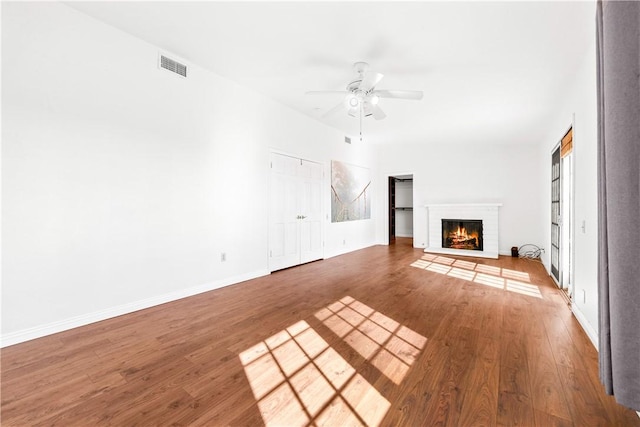 unfurnished living room featuring ceiling fan, hardwood / wood-style floors, and a fireplace