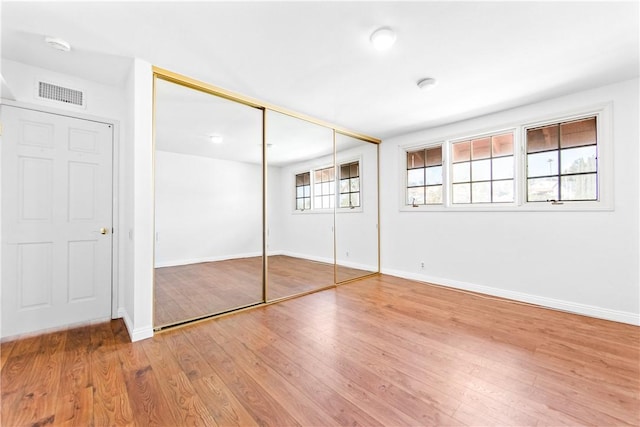 unfurnished bedroom featuring light hardwood / wood-style floors and a closet