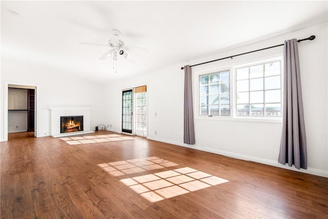 unfurnished living room featuring hardwood / wood-style flooring, ceiling fan, a fireplace, and vaulted ceiling