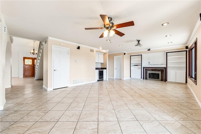 unfurnished living room featuring ornamental molding, ceiling fan with notable chandelier, light tile patterned floors, and beverage cooler