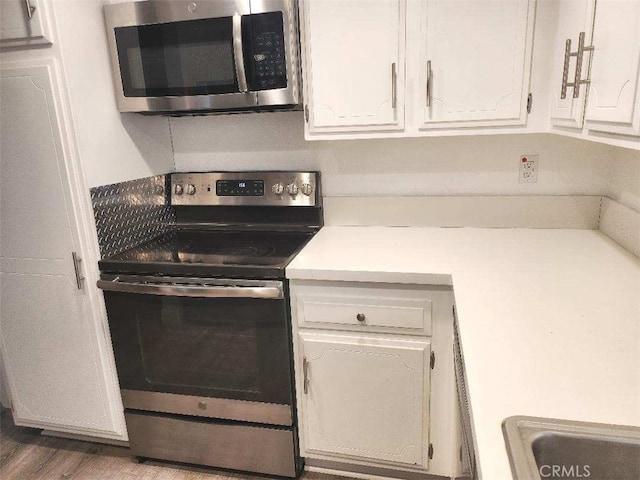 kitchen with white cabinetry and appliances with stainless steel finishes