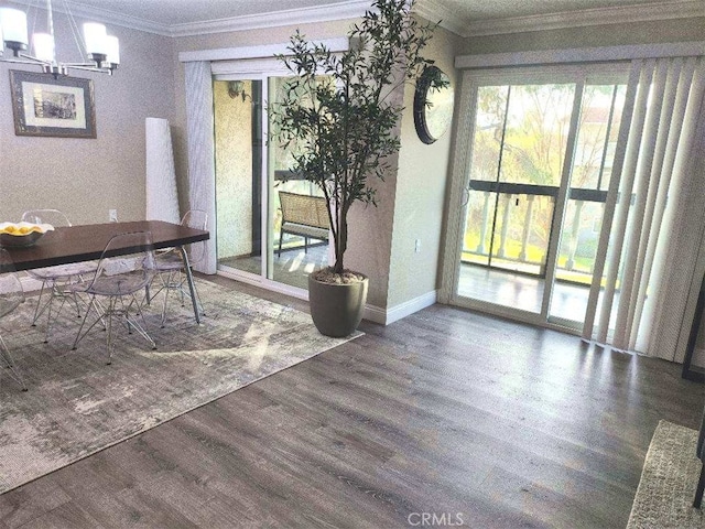 dining space with ornamental molding, dark wood-type flooring, and a chandelier