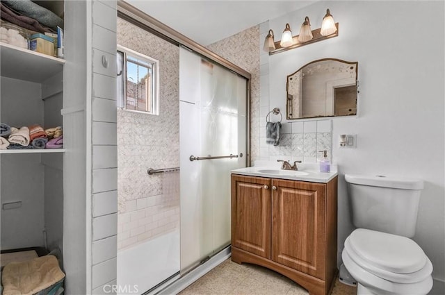 bathroom featuring vanity, backsplash, a shower with shower door, and toilet