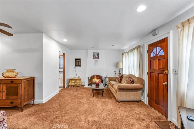 living area with ceiling fan, carpet, and a fireplace