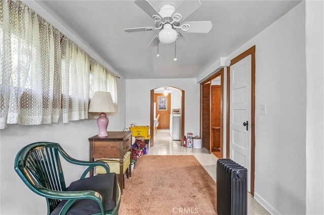 sitting room featuring ceiling fan and radiator