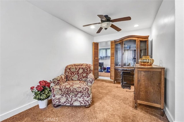 living area featuring ceiling fan and carpet floors