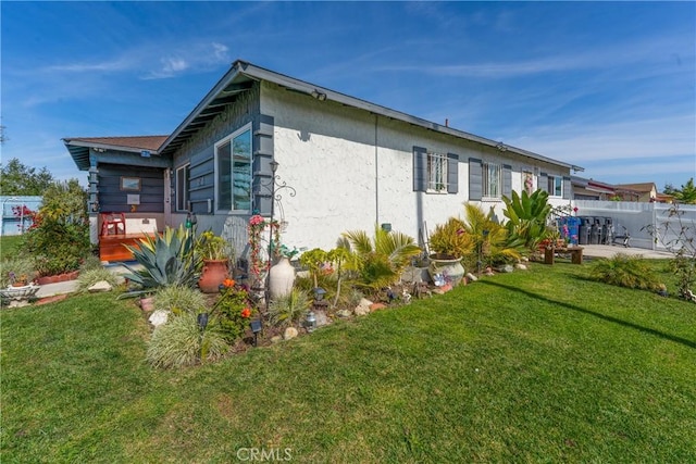 view of home's exterior featuring fence and a lawn