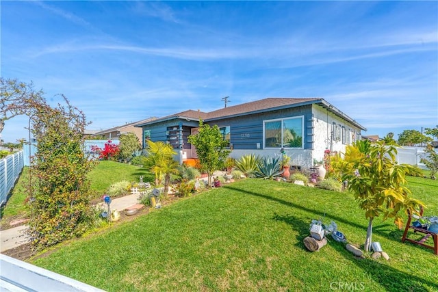 view of front facade featuring fence and a front yard