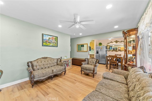 living room featuring light wood-type flooring, a ceiling fan, and recessed lighting