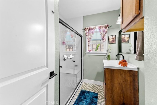 full bathroom featuring a stall shower, tile patterned floors, baseboards, and vanity