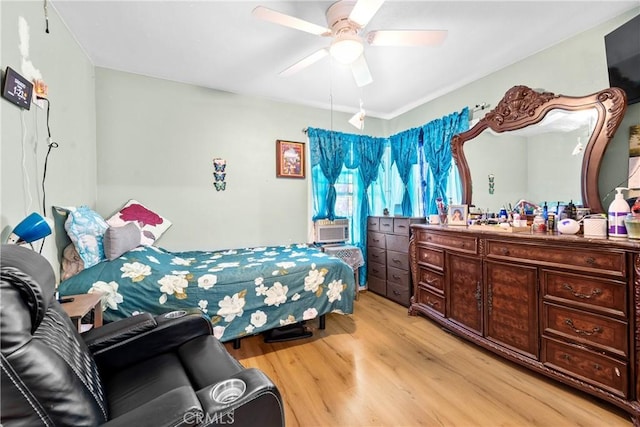 bedroom featuring light wood-style flooring, ceiling fan, and cooling unit