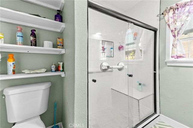 bathroom featuring a shower stall and toilet