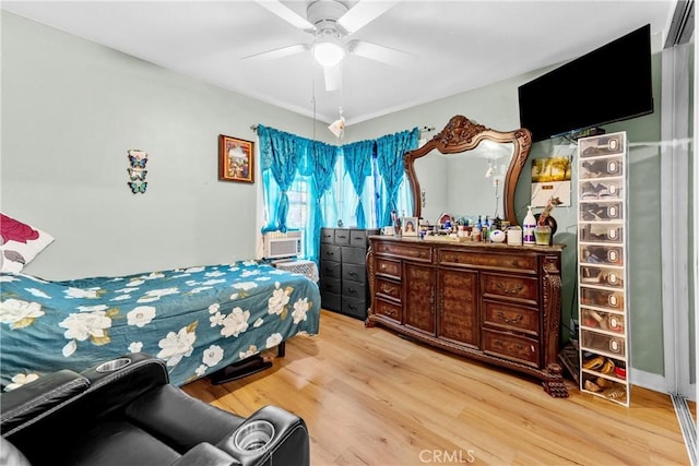 bedroom with ceiling fan, light wood-type flooring, and cooling unit