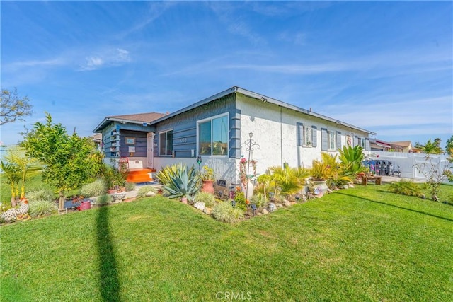 view of home's exterior with fence and a lawn