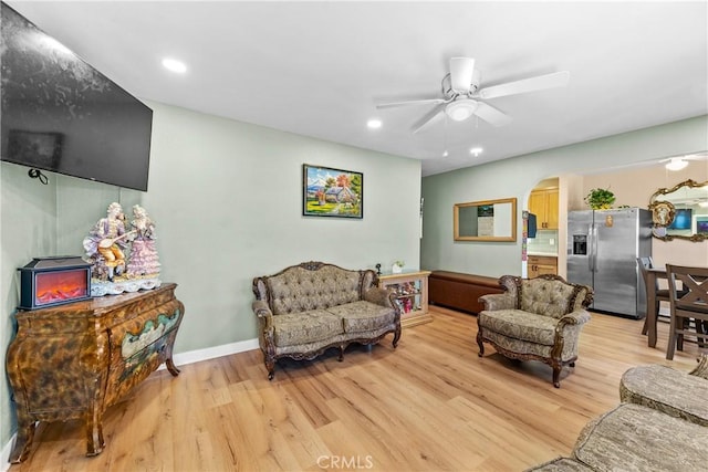 living room with ceiling fan and light wood-type flooring