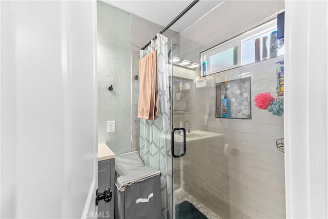 bathroom with a shower stall and vanity