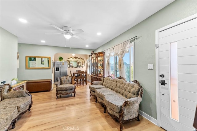 living room with light hardwood / wood-style flooring and ceiling fan