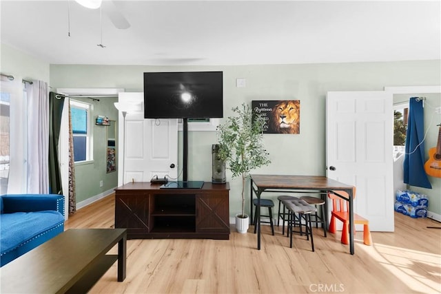 living room with ceiling fan and light hardwood / wood-style flooring