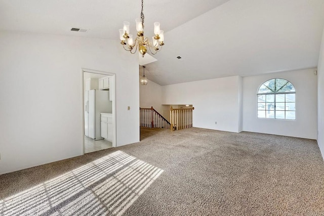 unfurnished living room with lofted ceiling, light colored carpet, and an inviting chandelier